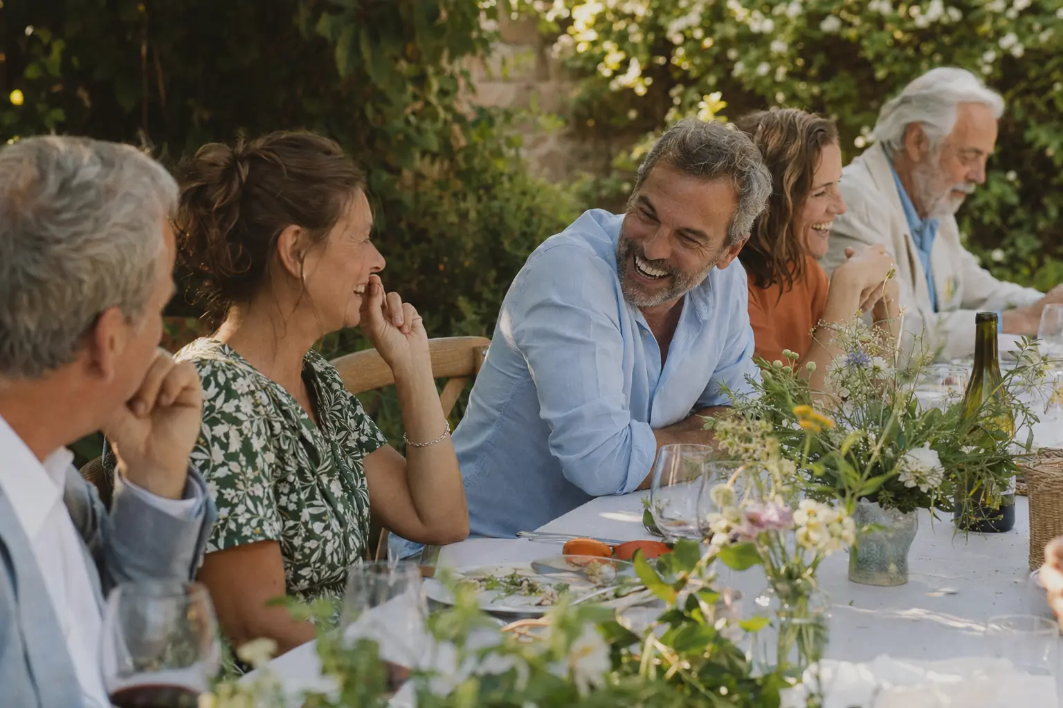Adult friends sharing a long garden lunch